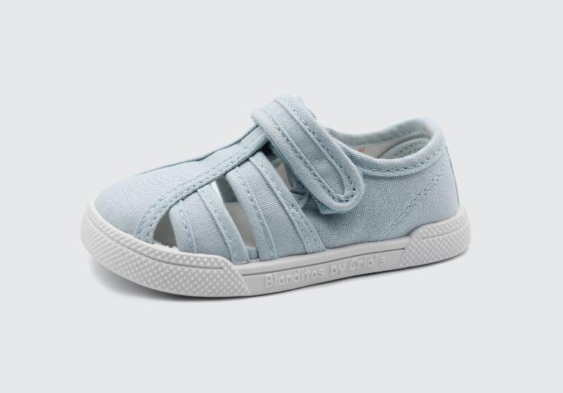 Sandália infantil estilo lona azul claro da Blanditos by Crio's, modelo fechado na frente com tiras e fecho de velcro, sola branca flexível.