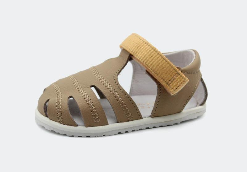 Sandália minimalista Barefoot Blanditos by Crio's em pele genuína cor arena, com fecho de velcro amarelo mostarda e sola fina, ideal para os primeiros passos.