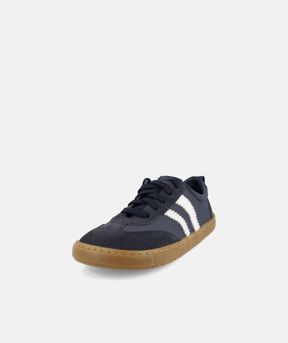 Sapatilha infantil Blanditos Delfin marinho, vista frontal oblíqua, com atacadores e três riscas brancas laterais, sola castanha.