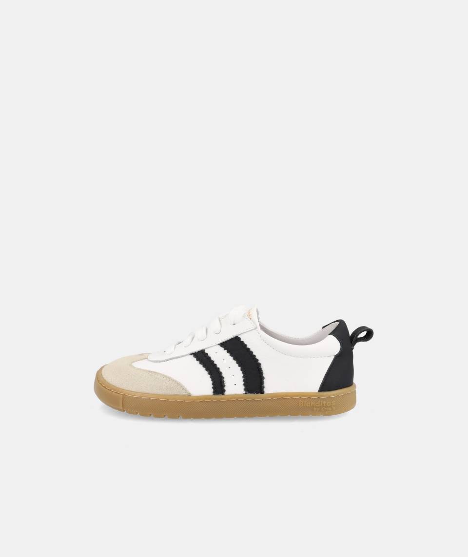 Sapatilha respeitadora Blanditos Delfin, vista lateral exterior, cor branca, detalhes pretos e sola plana castanha.