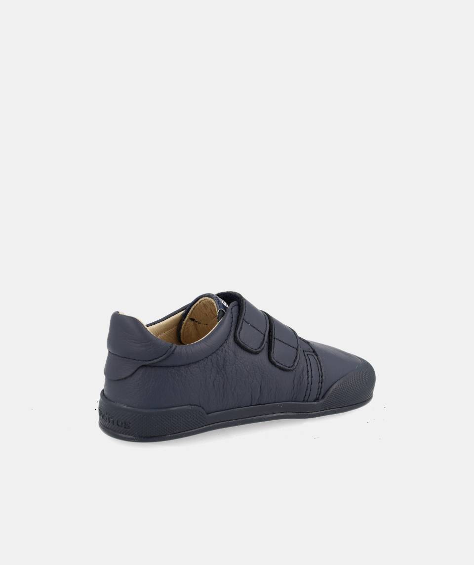 Perspetiva de três quartos da sapatilha barefoot Blanditos Londres Navy, focando no ajuste com duas tiras de velcro e a construção flexível.