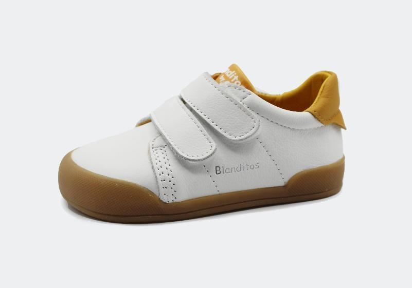 Sapatilha infantil barefoot Blanditos Londres em pele branca com detalhes ocre, fecho duplo velcro e sola castanha.