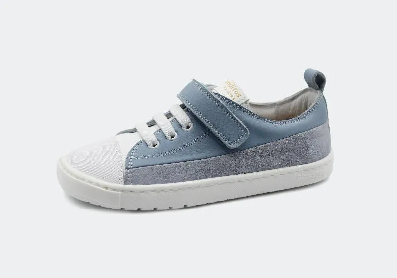Sapatilha Barefoot para criança Blanditos Ancla por Crio's na cor Azul. Calçado respeitador em camurça azul clara com biqueira branca, sola flexível zero drop, atacadores elásticos e fecho de velcro. Vista lateral. Calçado Barefoot Blanditos.