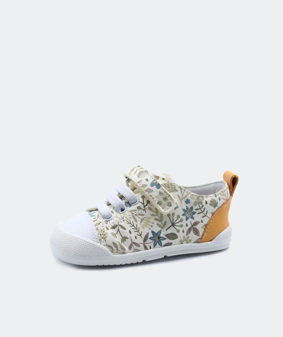 Sapatilha Blanditos by Crio's Ariel cor creme com padrão floral suave e detalhe amarelo mostarda no calcanhar, vista lateral. Calçado Barefoot Respeitador para criança.