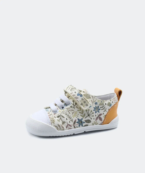 Sapatilha Blanditos by Crio's Ariel cor creme com padrão floral suave e detalhe amarelo mostarda no calcanhar, vista lateral. Calçado Barefoot Respeitador para criança.