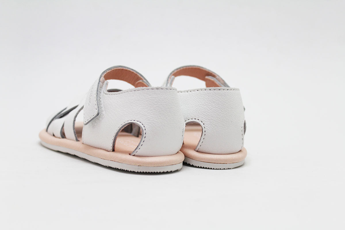 Vista traseira de um par de sandálias Blanditos by Crio's brancas, focando o calcanhar e o interior rosa claro.