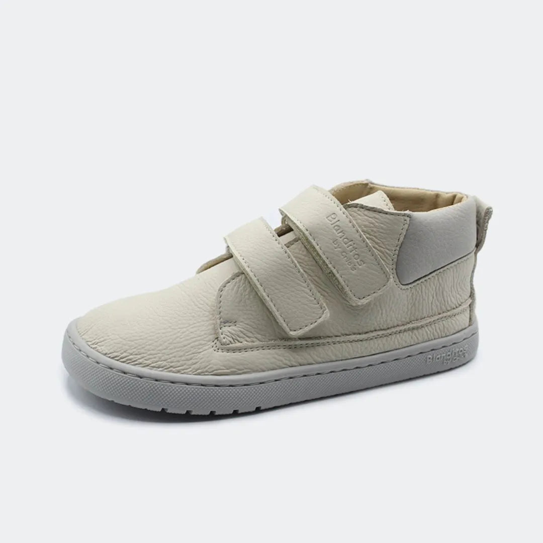 Sapatilha Blanditos Etna cor Ivory (creme/branco sujo), vista de perfil com fundo branco. Calçado Respeitador Barefoot para criança, sola cinza clara flexível e velcro.