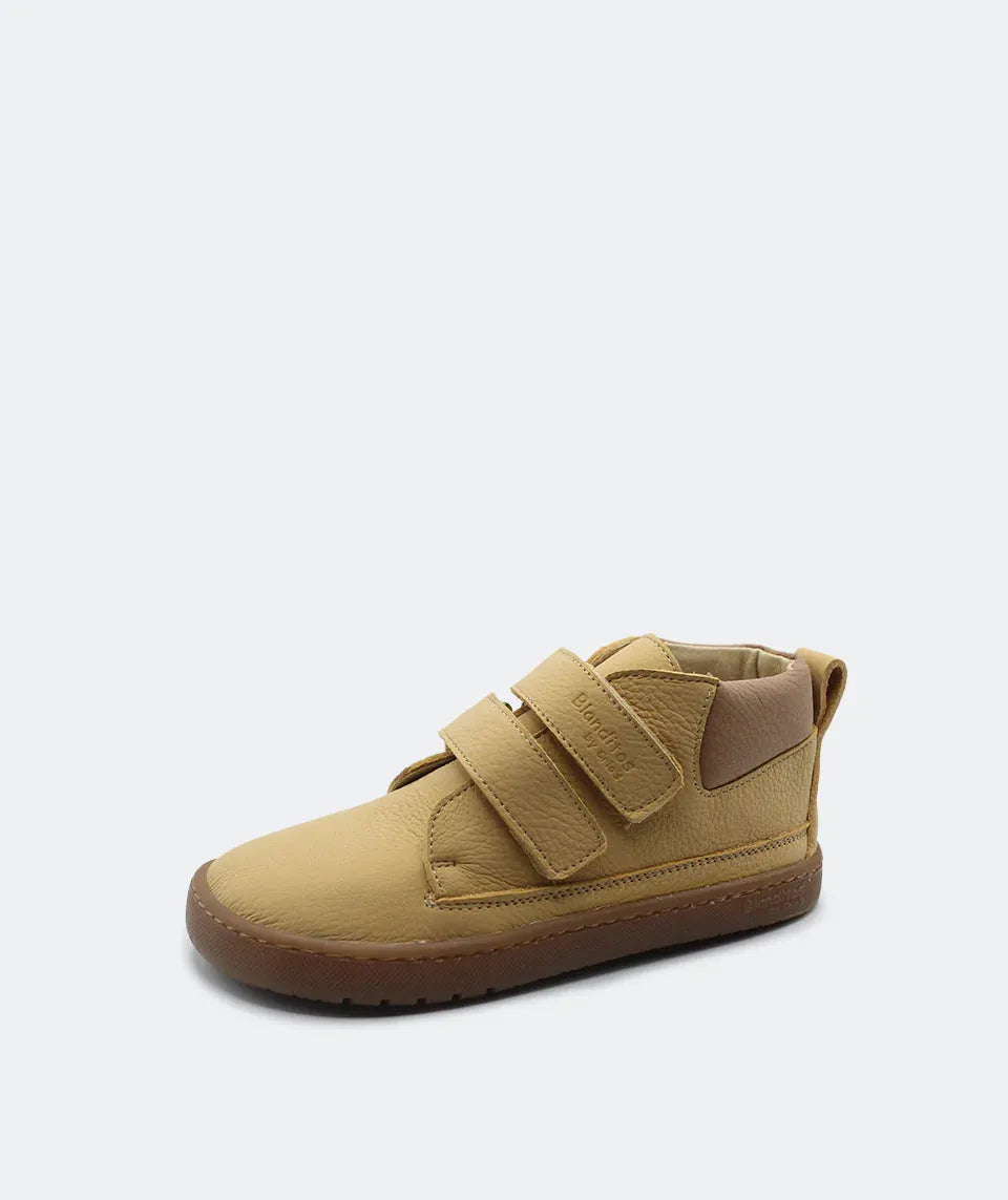 Sapatilha Blanditos Etna cor Mostarda, vista de perfil isolada. Calçado infantil Barefoot com sola castanha flexível e duas tiras de velcro.