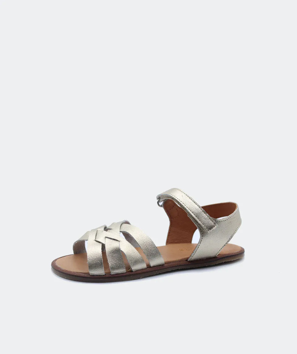 Sandália Blanditos Ithaca em tom champanhe, com tiras cruzadas em couro natural, sola fina e biqueira reforçada. Ideal para eventos e passeios.