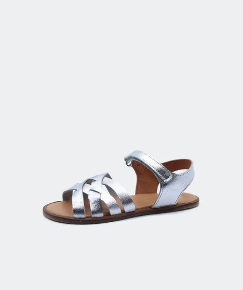 Sandália Blanditos Ithaca em prata, com acabamento metálico, tiras cruzadas de couro natural e sola fina para uma experiência barefoot.