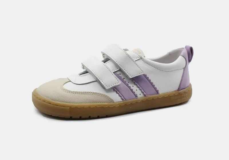 Vista lateral das sapatilhas Blanditos Marea BR (branco/lilás), calçado barefoot infantil com base branca, risca lateral lilás, velcro branco e sola cor de borracha natural. Calçado Respeitador.