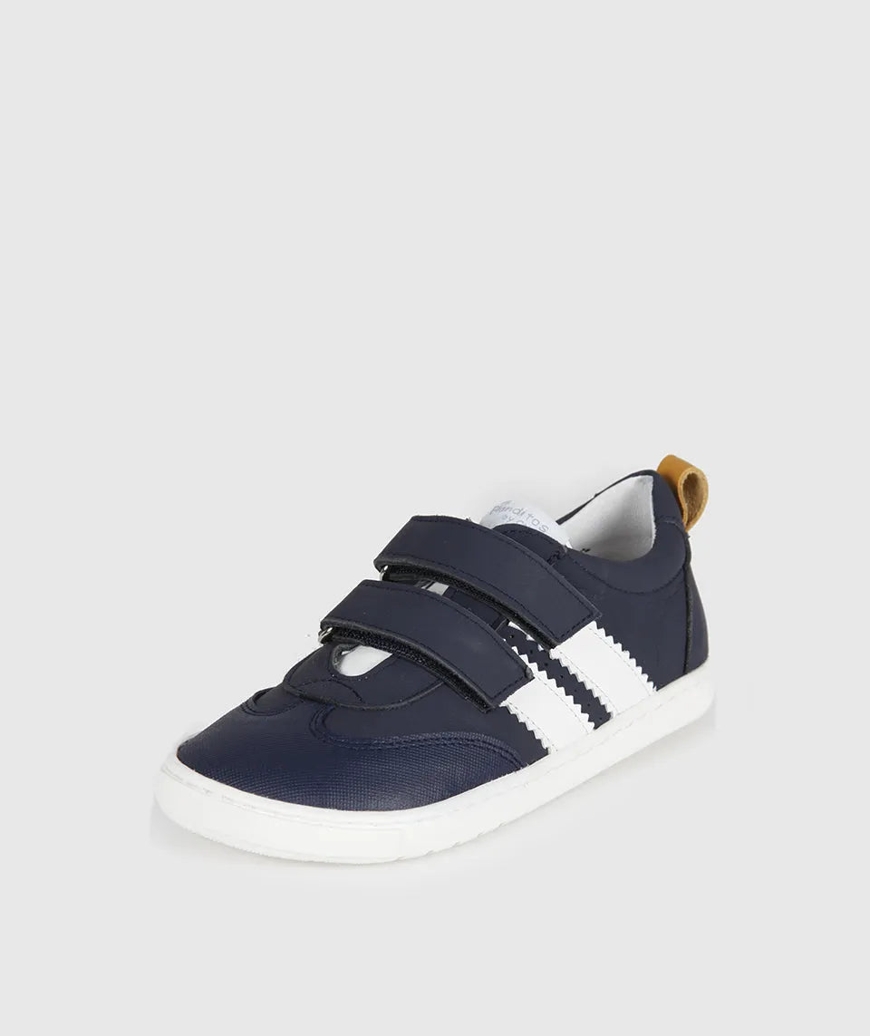 Vista lateral das sapatilhas Blanditos Marea Marino (azul-marinho), calçado barefoot infantil com risca lateral branca, detalhe amarelo no calcanhar e velcro duplo. Calçado Respeitador.