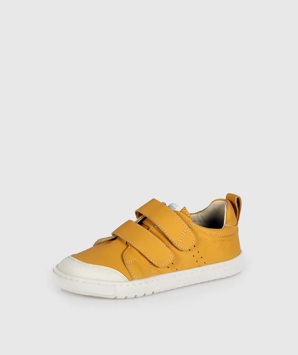 Sapatilha Blanditos Rio by Crio's Ocre (Amarelo Mostarda). Calçado respeitador infantil barefoot com sola branca e duas tiras de velcro. Vista lateral.