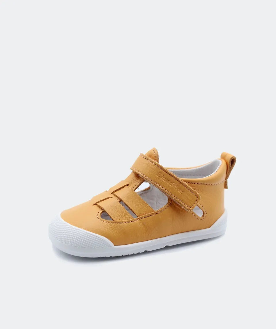 Sandália Blanditos by Crio's em amarelo – Sandália barefoot amarela com sola branca e fecho em velcro, com design flexível e respirável para conforto e liberdade de movimentos.
