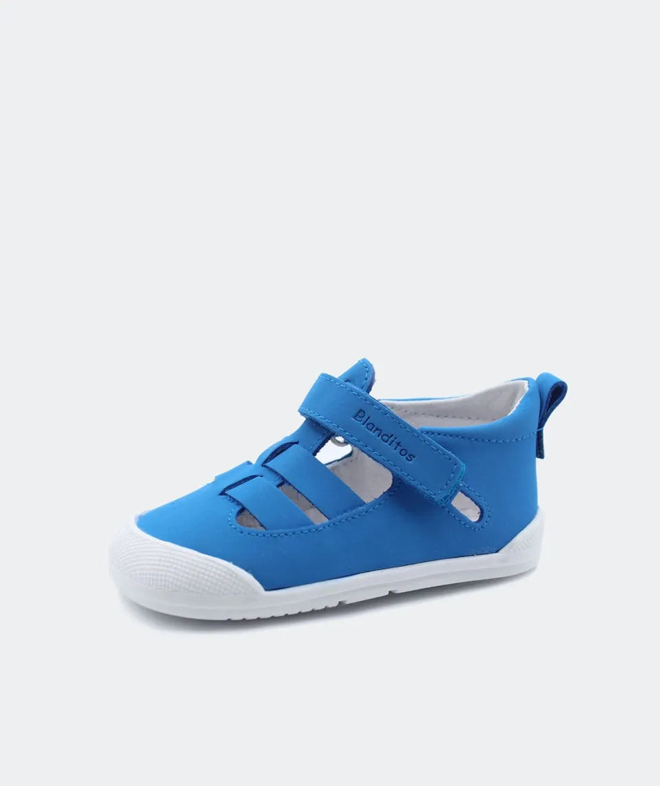 Sandália Blanditos by Crio's em azul – Sandália barefoot azul vibrante com sola branca e design respirável, ideal para o verão e para promover o desenvolvimento natural dos pés.
