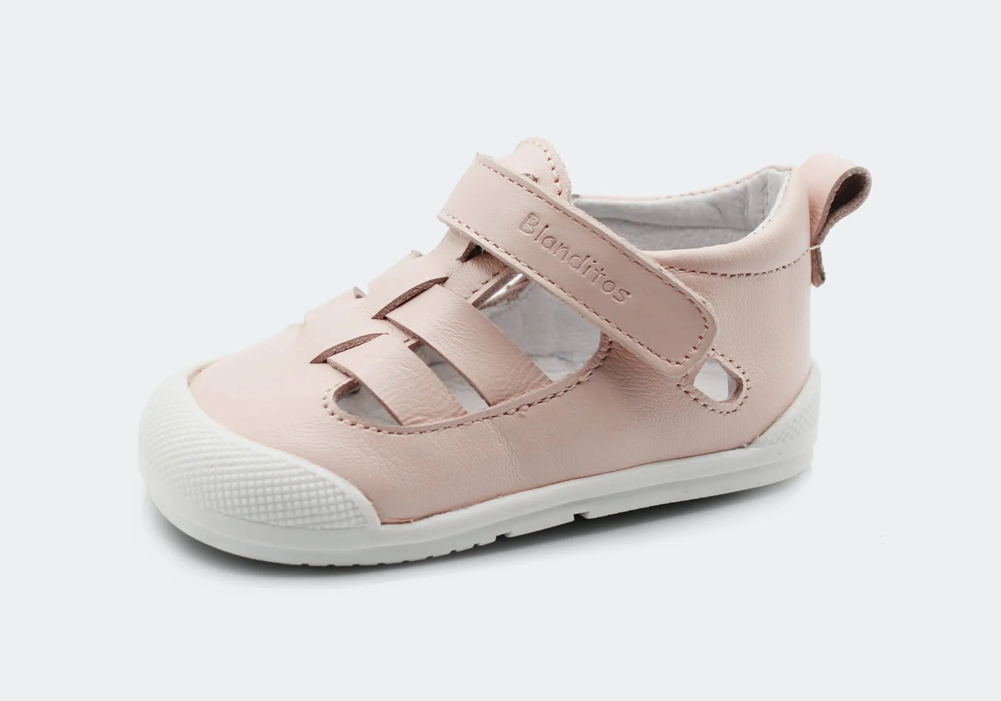 Sandália Blanditos by Crio's em rosa – Sandália barefoot rosa suave com sola branca e fecho em velcro, oferecendo conforto e espaço para os dedos.
