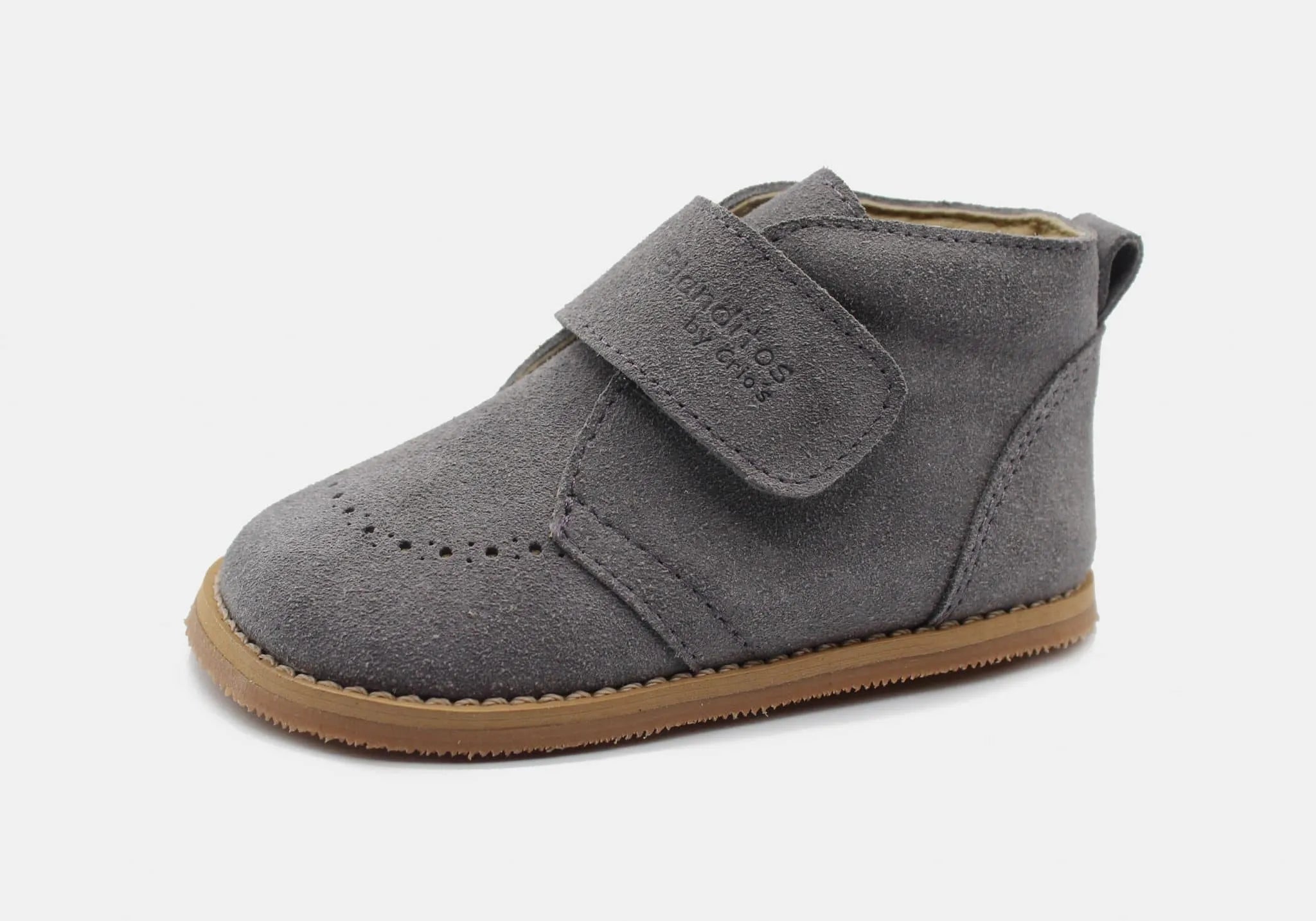 Blanditos Turin Gris – Sapato Blanditos de cerimónia em couro natural cinza, com fecho em velcro e sola fina de 3,5 mm. Formato largo que permite o movimento natural dos dedos.
