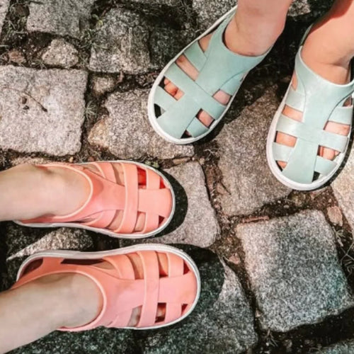Crianças a usar sandálias Boatilus Bioty em diferentes cores em pavimentação de pedra.
