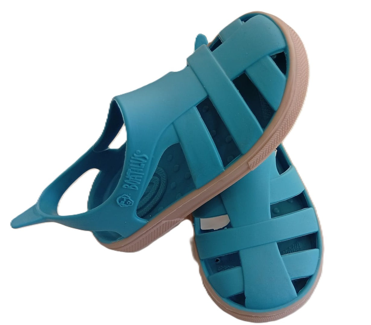 Sandálias minimalistas Boatilus Bioty em azul caraíbe e bege, inclinadas, com o logótipo Boatilus visível na lateral.