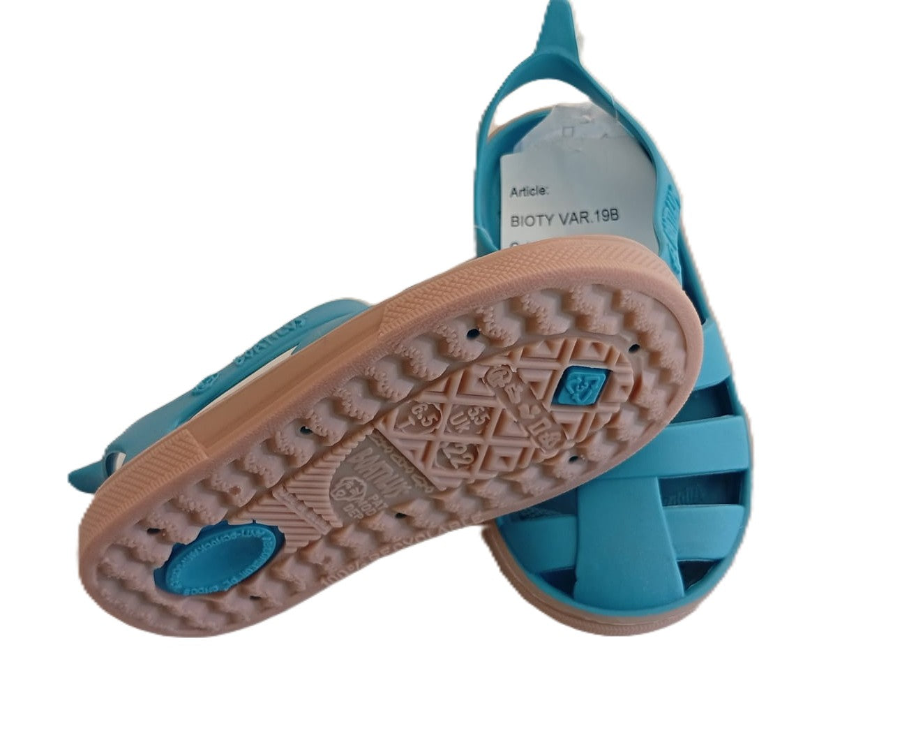 Vista da sola bege das sandálias Boatilus Bioty em azul caraíbe, mostrando o padrão antiderrapante e detalhes da marca.