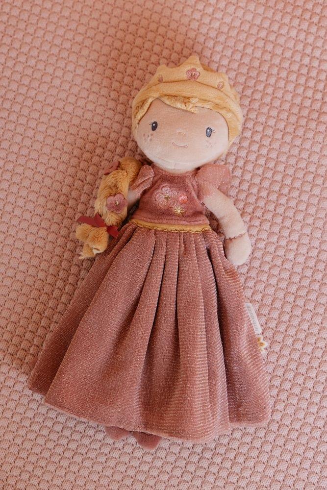 Boneca Princesa Julia da Little Dutch em primeiro plano, deitada sobre um tecido rosa texturizado, mostrando o seu vestido e trança.