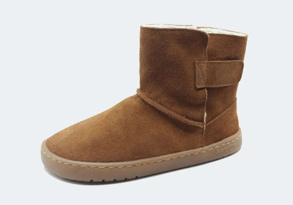Bota Hielo Blanditos by Crio's na cor Couro (castanho). Vista lateral do calçado barefoot e respeitador para criança, em couro tipo camurça, sola bege plana e flexível, com fecho de velcro. Calçado Barefoot.
