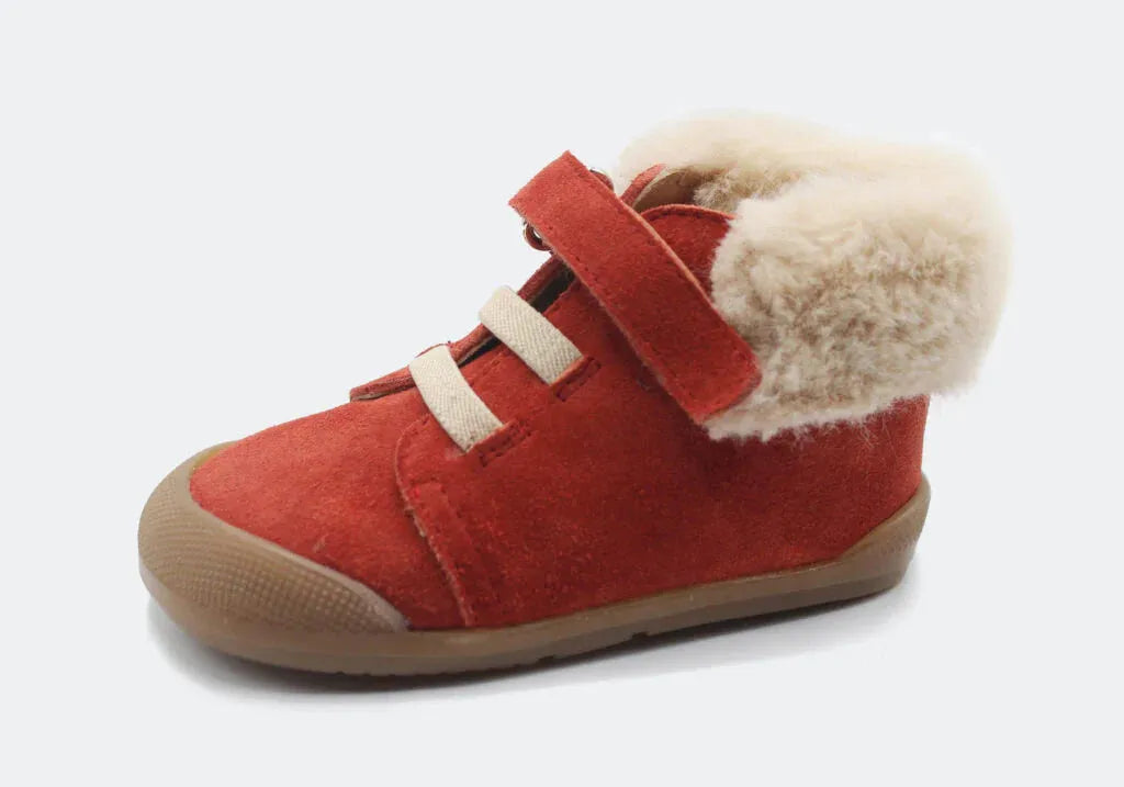 Vista lateral da Bota Sierra da Blanditos by Crio's na cor Caldera (vermelho-tijolo). Calçado barefoot e calçado respeitador infantil em pele tipo camurça caldera, com forro quente cor creme, biqueira reforçada e fecho de velcro. Calçado Barefoot.