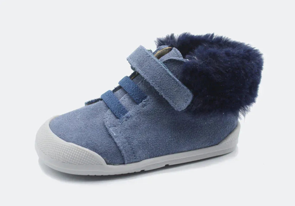 Vista lateral da Bota Sierra da Blanditos by Crio's na cor Jeans (azul). Calçado barefoot e calçado respeitador infantil em pele tipo camurça azul, com forro quente azul escuro, biqueira reforçada branca e fecho de velcro. Calçado Barefoot.