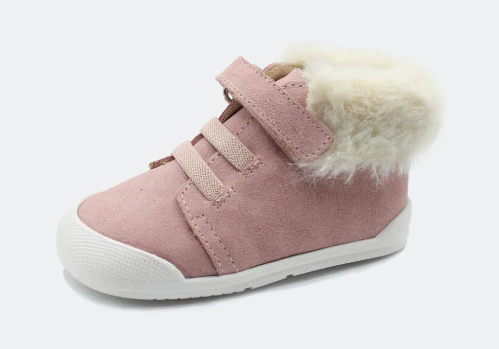Vista lateral da Bota Sierra da Blanditos by Crio's na cor Rosa. Calçado barefoot e calçado respeitador infantil em pele tipo camurça rosa, com forro quente cor creme, biqueira reforçada branca e fecho de velcro. Calçado Barefoot.