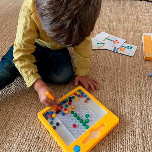 Criança a brincar com o BRAINTOYS Imadots MINI. Tabuleiro magnético educativo para estimular a criatividade e concentração.