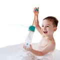 Menino a rir e a divertir-se com um esguicho de água. Brinquedos de exterior ideais para praia e piscina.