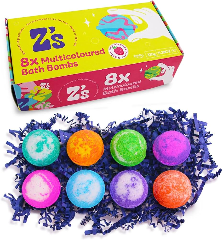 Caixa amarela e rosa com a marca Z's, anunciando 8 bombas de banho multicores, com 6 bombas coloridas expostas sobre aparas de papel azul.