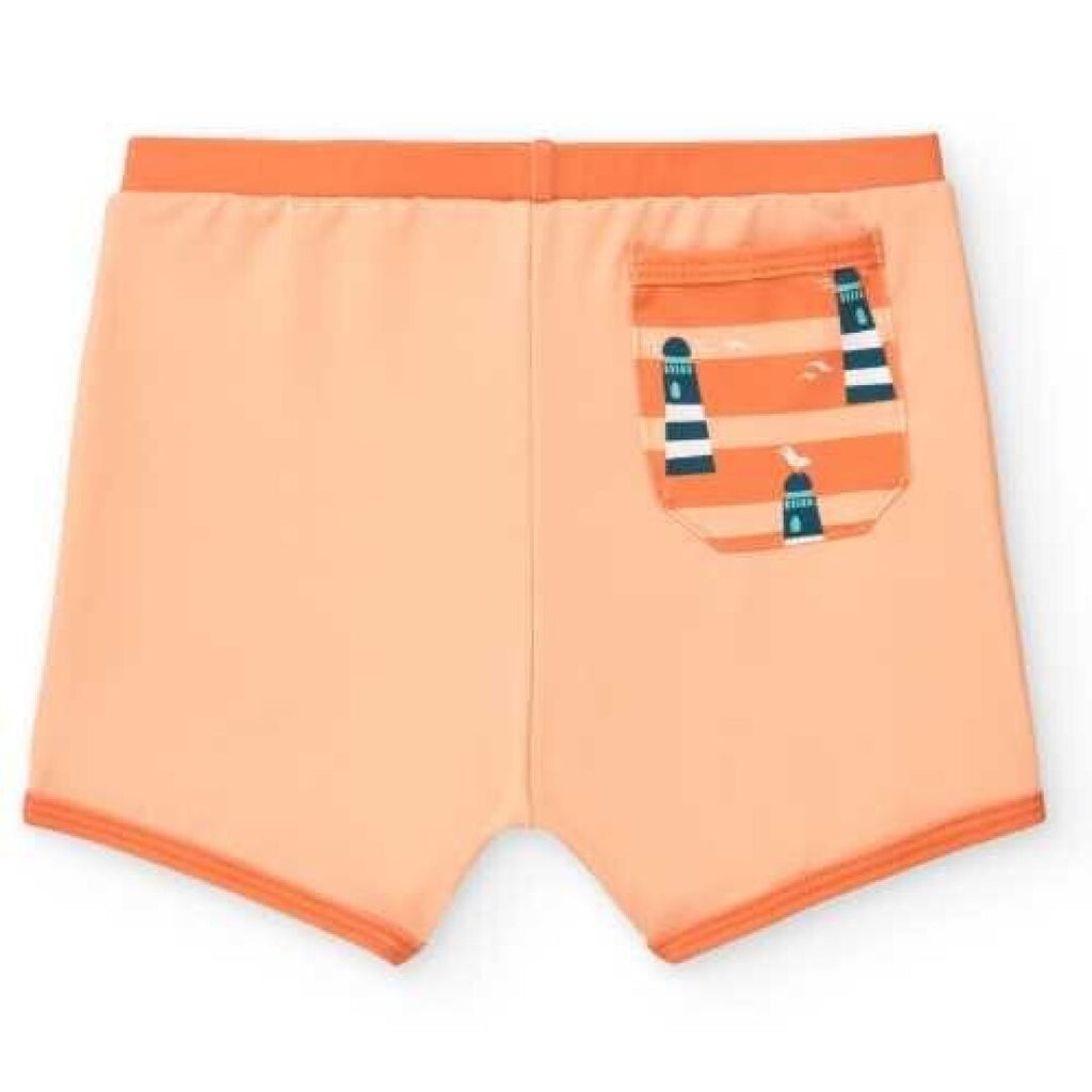 Boxer de praia infantil BtBox em lycra cor pêssego, vista traseira, com bolso decorativo de faróis e riscas laranja.