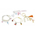 Exemplos das quatro peças de joalharia completas: pulseiras com pendentes de fruta, um porta-chaves com flamingo e um alfinete decorativo com borla.