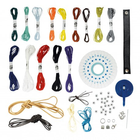 Conteúdo completo do kit "Buki Constrói Pulseiras da Amizade": fios de algodão coloridos, roda de tecelagem, pulseira de couro sintético, berloques e fechos.