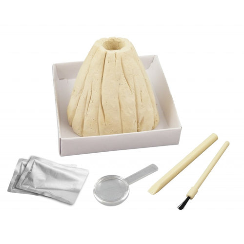 Componentes do kit Mini Vulcão Buki: molde de vulcão de gesso, pacotes de reagentes, colher, cinzel e pincel, dispostos numa caixa branca.