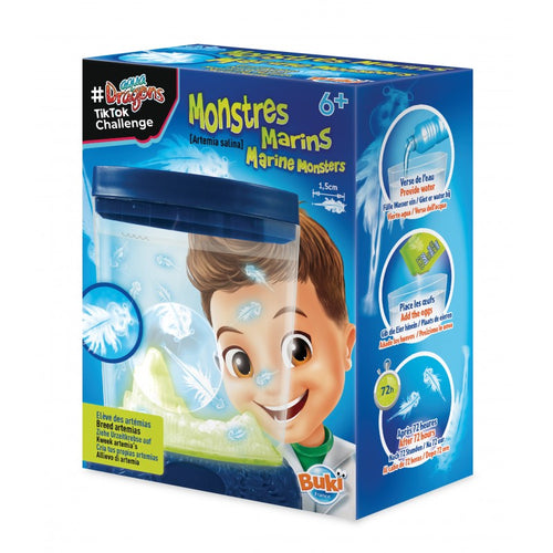 Caixa do kit científico Buki Monstros Marinhos, mostrando o aquário fosforescente e um rapaz a observar as artémias, com instruções de 72 horas.