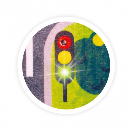 Close-up de um semáforo interativo no tapete, com a luz verde LED acesa, destacando a funcionalidade luminosa.