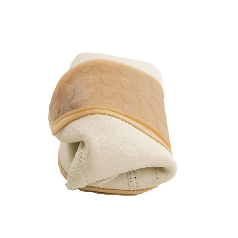 Detalhe da extrema flexibilidade da sapatilha Bunny Barefoot, dobrada sobre si mesma, mostrando a sola de borracha clara.