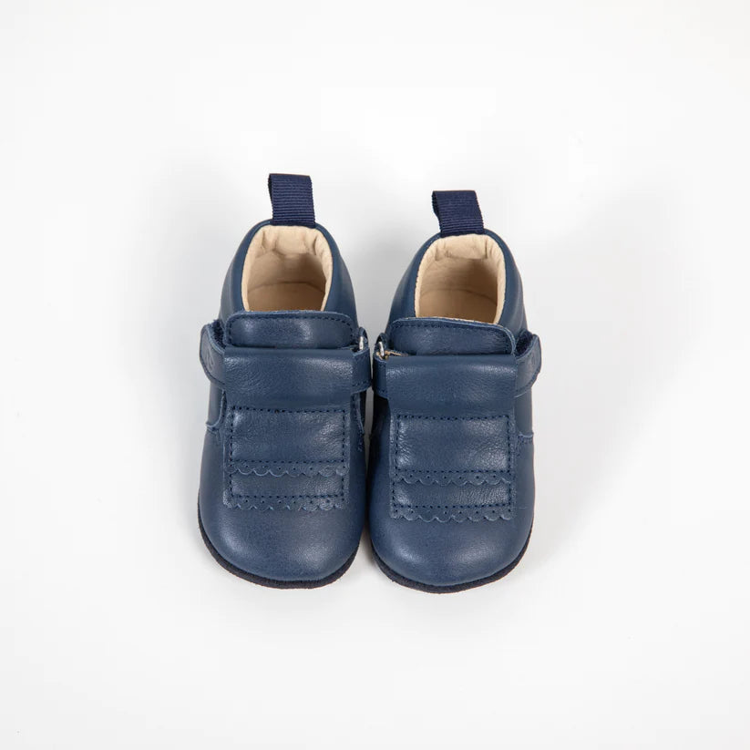 Par de sapatinhos Bunny Barefoot Girafinha em pele azul marinho, com fecho de velcro e detalhe festonado. Fundo branco.