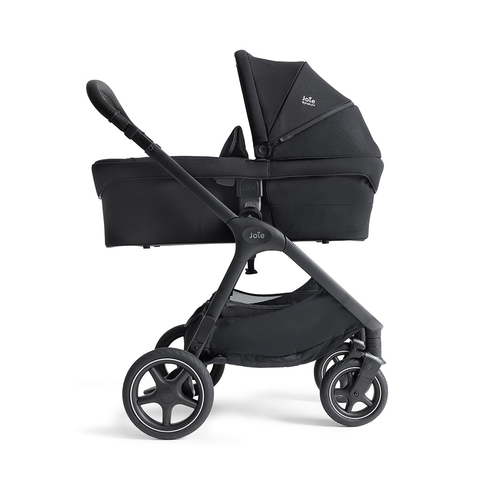 Alcofa Joie Ramble XL com capa de chuva personalizada instalada, pronta para uso em condições meteorológicas adversas.