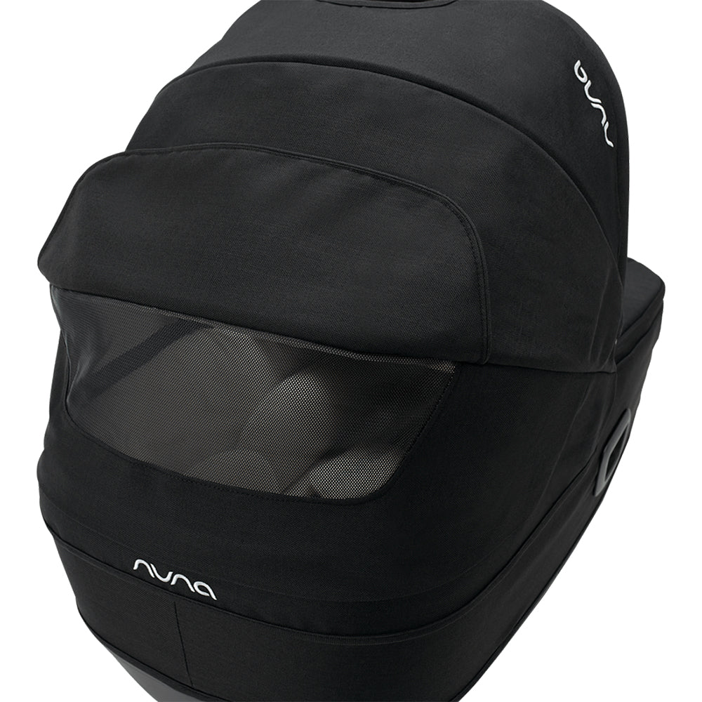 Detalhe da capota da alcofa Nuna Cari Next preta, focando na janela de ventilação em rede e no logótipo Nuna.