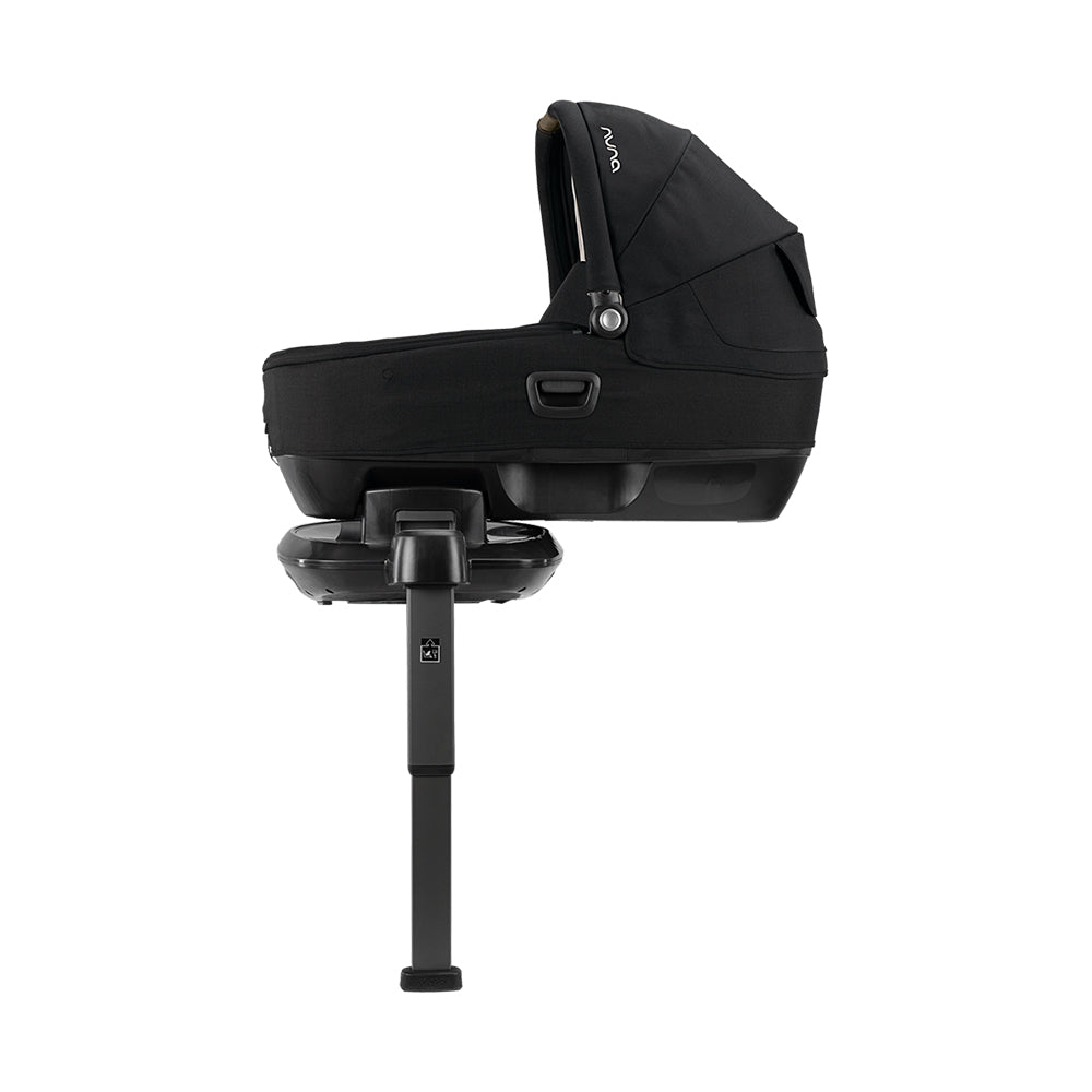 Alcofa Nuna Cari Next preta isolada, montada numa base de apoio com perna estabilizadora, ideal para uso como berço.