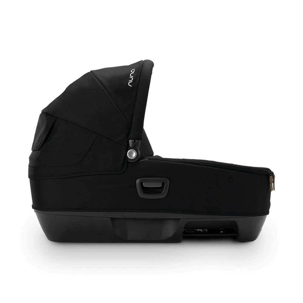 Cadeira auto alcofa Nuna Cari Next preta, vista lateral completa, destacando o design moderno e o capuz ajustável.