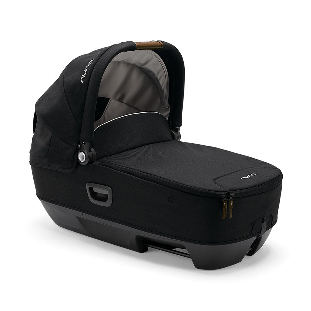 Cadeira auto alcofa Nuna Cari Next preta, vista em ângulo, mostrando o formato ergonómico e a base compatível com o sistema modular.