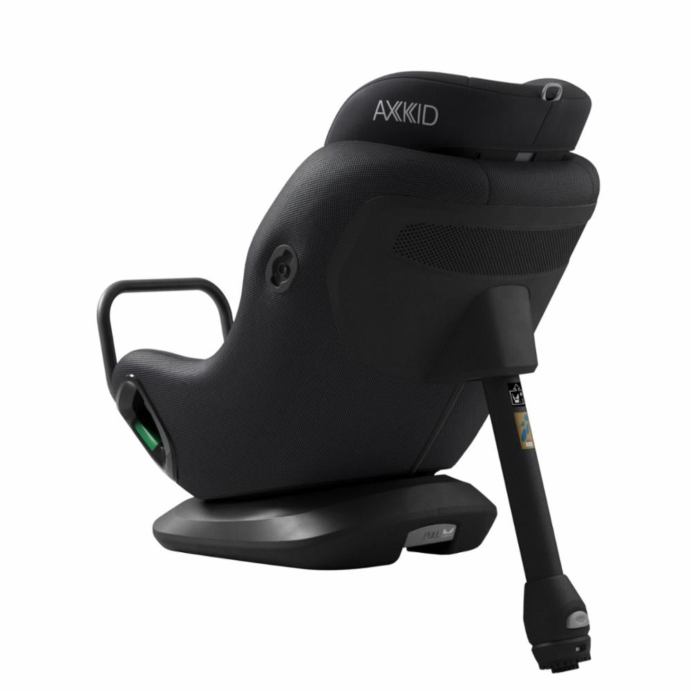 Cadeira auto AXKID Minikid CORE preta, vista traseira-lateral, evidenciando a base e o mecanismo de ajuste.