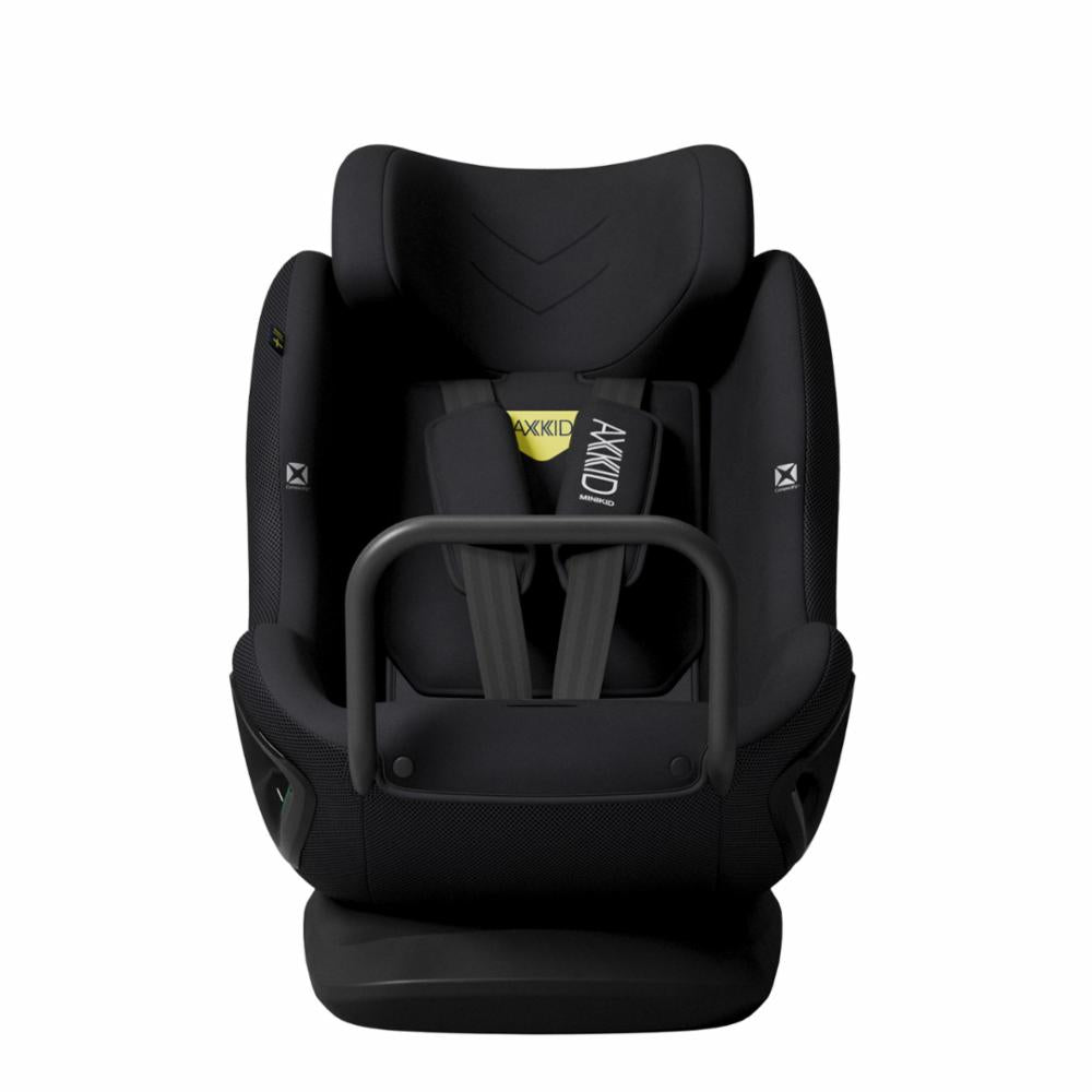 Cadeira auto AXKID Minikid CORE preta, vista frontal, com os cintos de segurança centrados e etiqueta AXKID amarela visível.