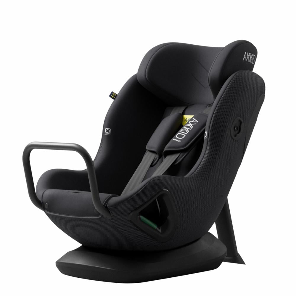 Cadeira auto AXKID Minikid CORE preta, vista lateral, enfatizando a altura do encosto e o logótipo AXKID no arnês.
