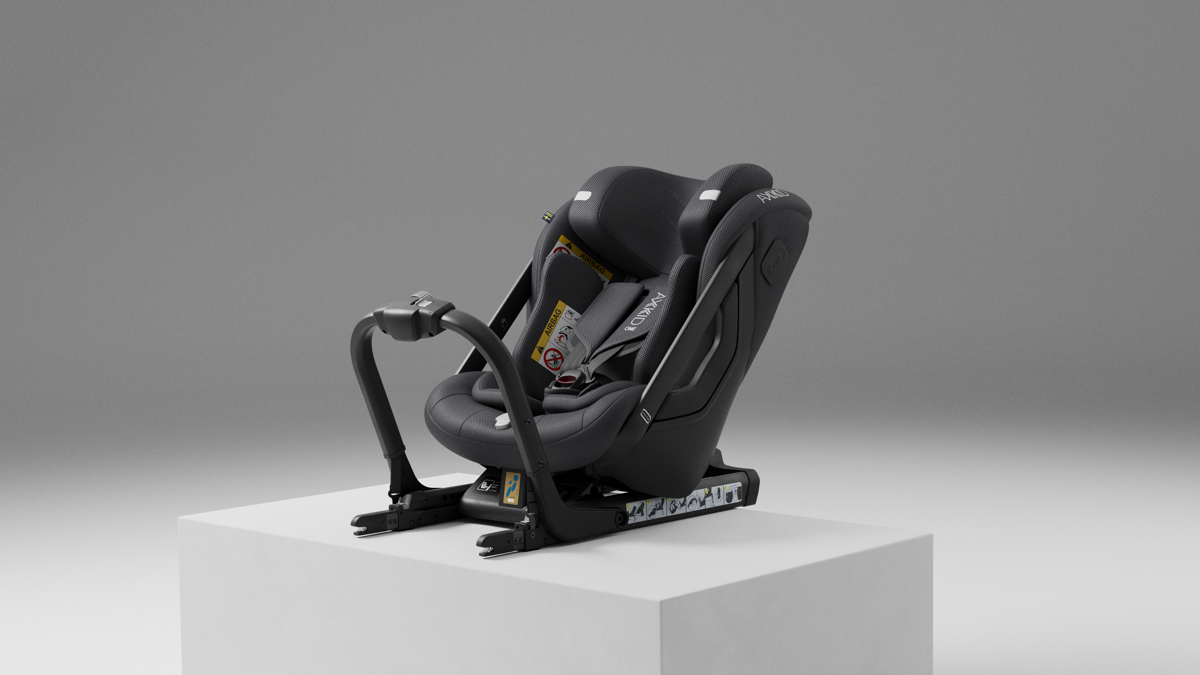 Cadeira Auto Axkid ONE 3 MESH preta, vista de lado, com a barra de apoio frontal estendida, sobre um pedestal cinzento.