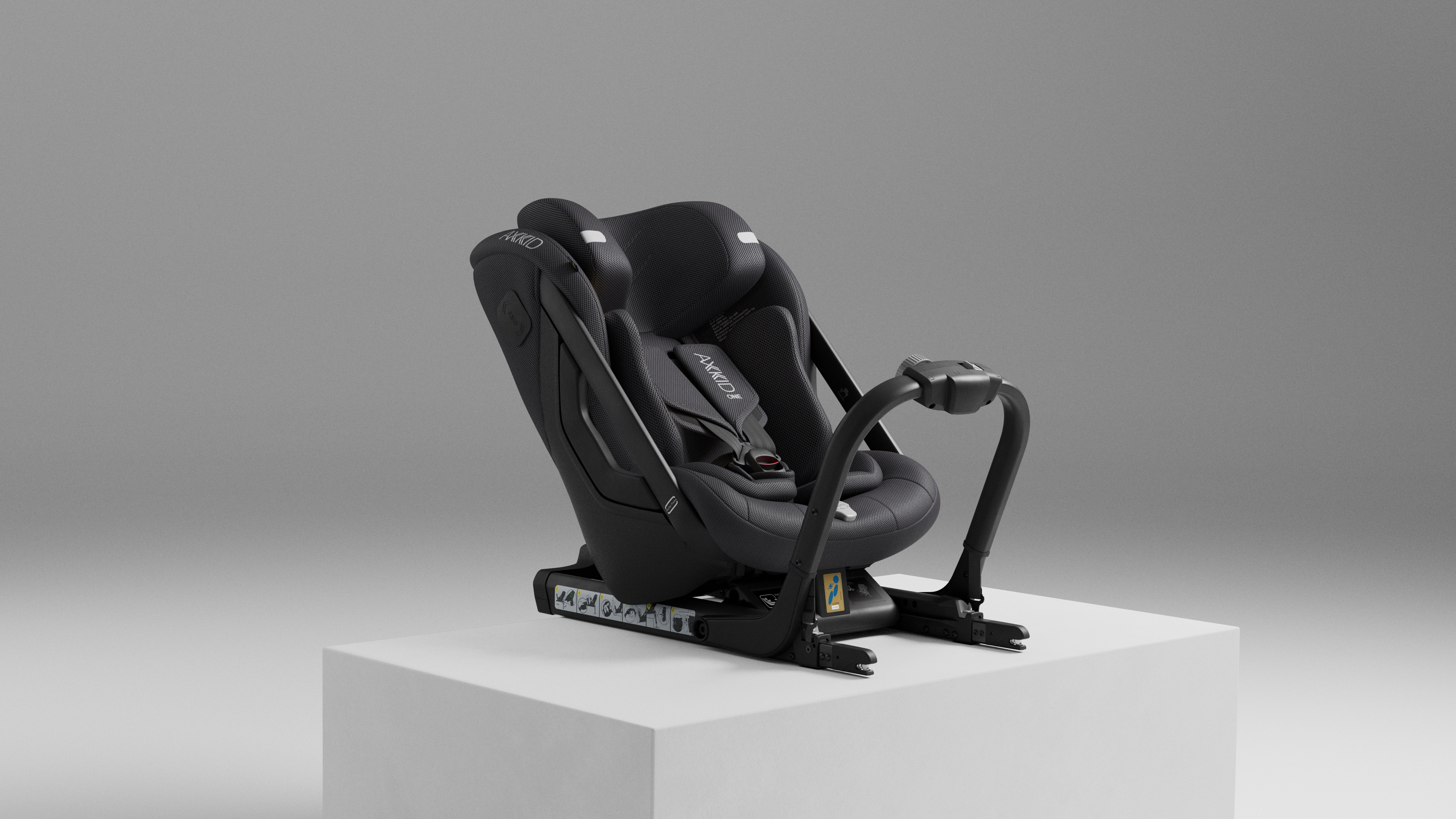 Cadeira Auto Axkid ONE 3 MESH preta, vista de lado, sobre um pedestal branco, destacando o design ISOFIX e o apoio de cabeça ASIP.